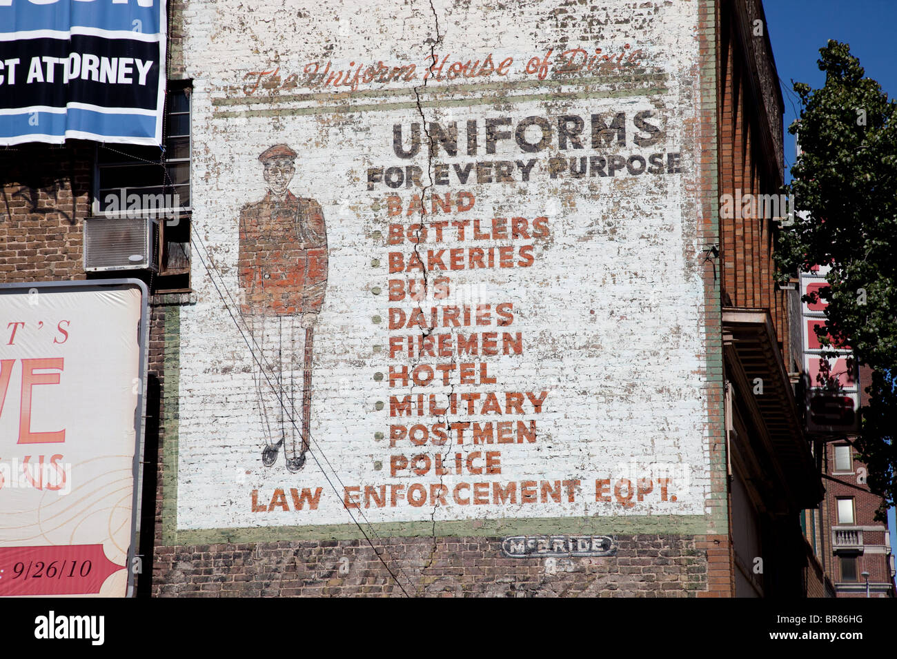 An old advertisement for uniforms graces the wall of an old building in Birmingham, Alabama Stock Photo