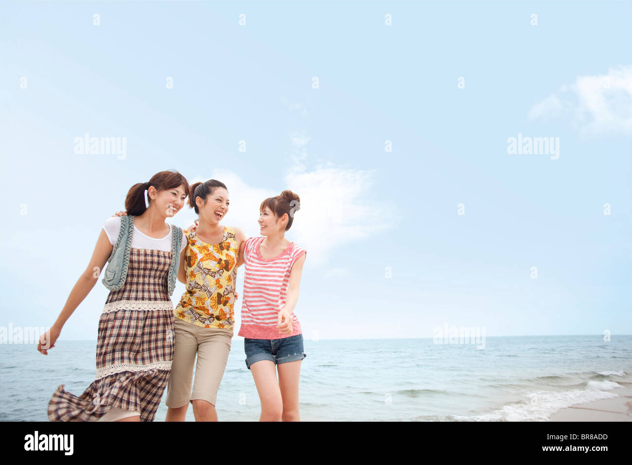 Three young women walking side by side at beach, copy space Stock Photo ...