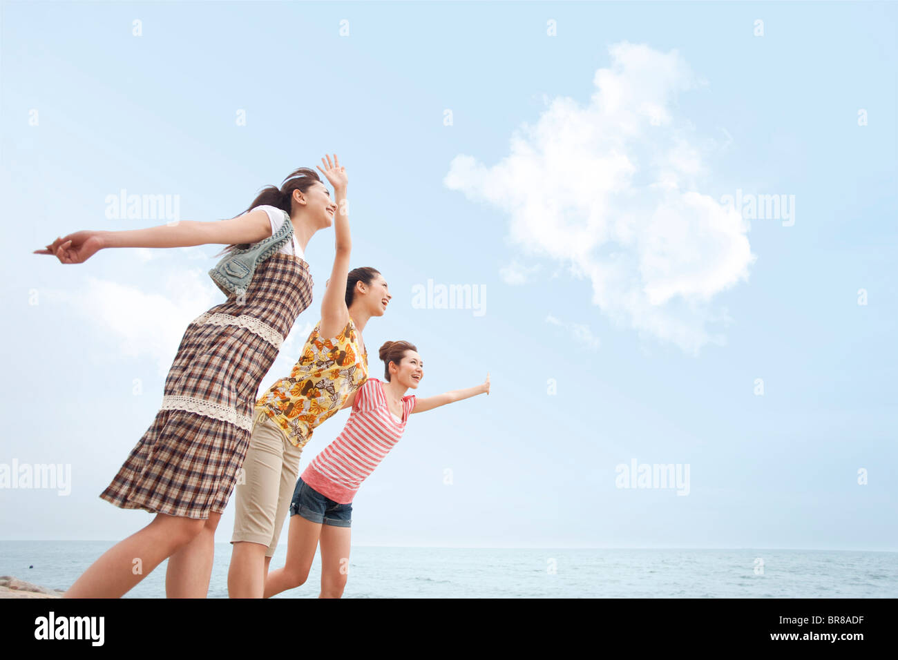 Three young women walking side by side at beach, copy space Stock Photo ...