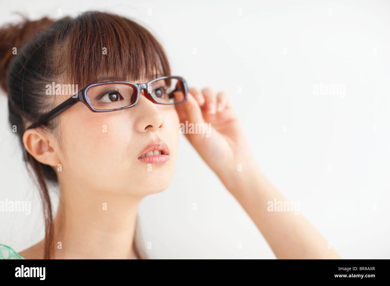 Young woman wearing glasses, white background Stock Photo - Alamy