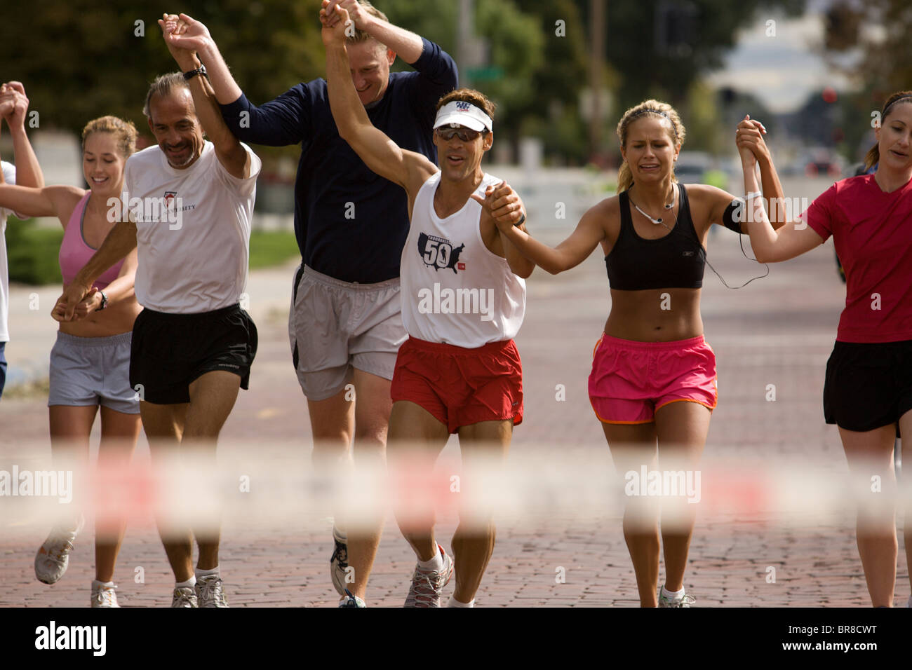 Runners hold hands as they cross the finish line during a marathon in