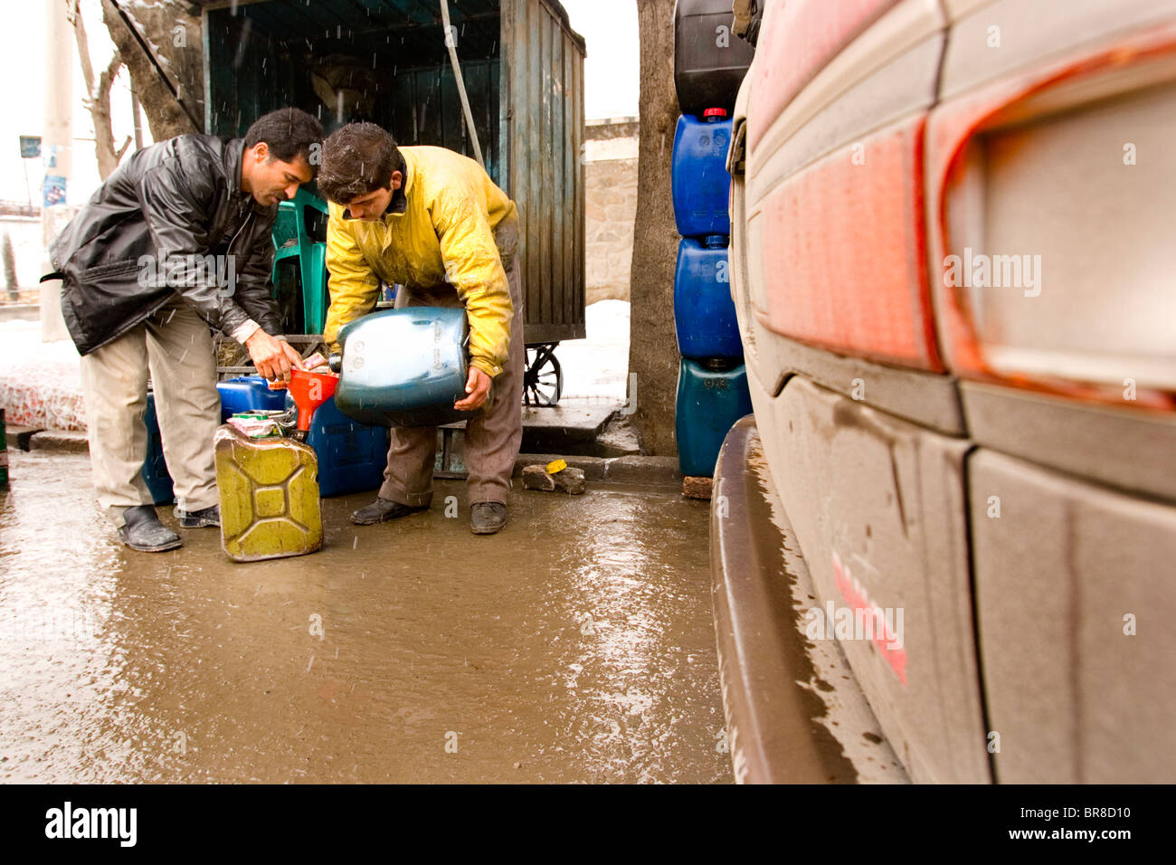 At a makeshift gas station in Kabul customers fill jerry cans with gas