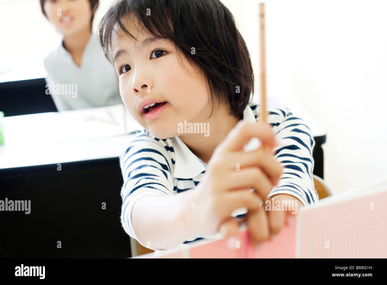 Girl holding a pencil and notebook Stock Photo - Alamy