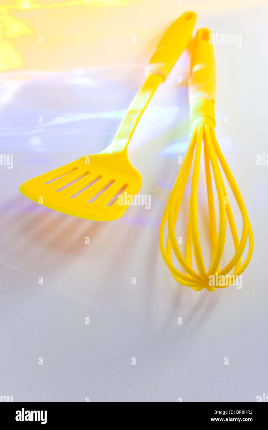 Yellow whisk and spatula, white background Stock Photo - Alamy