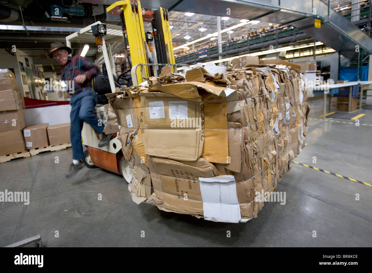 A man moving recycling boxes with a forklift in a clothing distribution