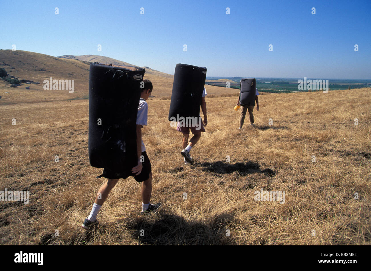 Three climbers walking with crash pads in Rocky Hill California. Stock Photo