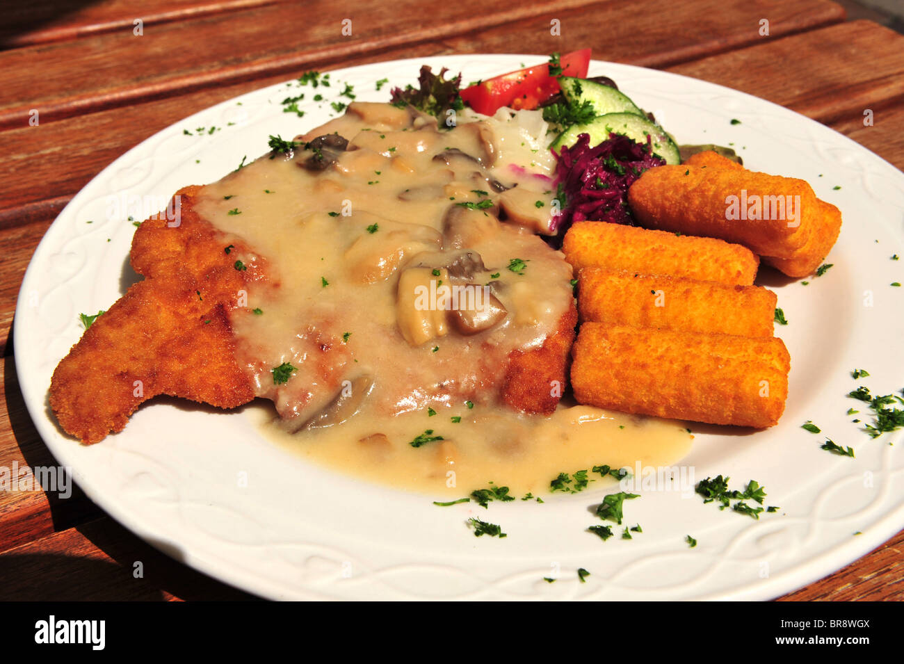Typical German dinner of a Veal Schnitzel cutlet, croquette potatoes