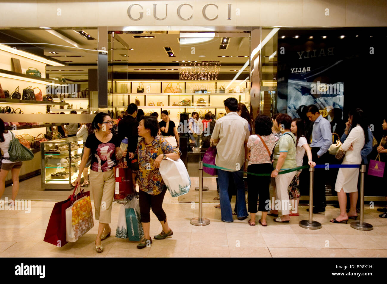 Shoppers Wait Their Turn To Enter A Boutique In Singapore Stock Photo 