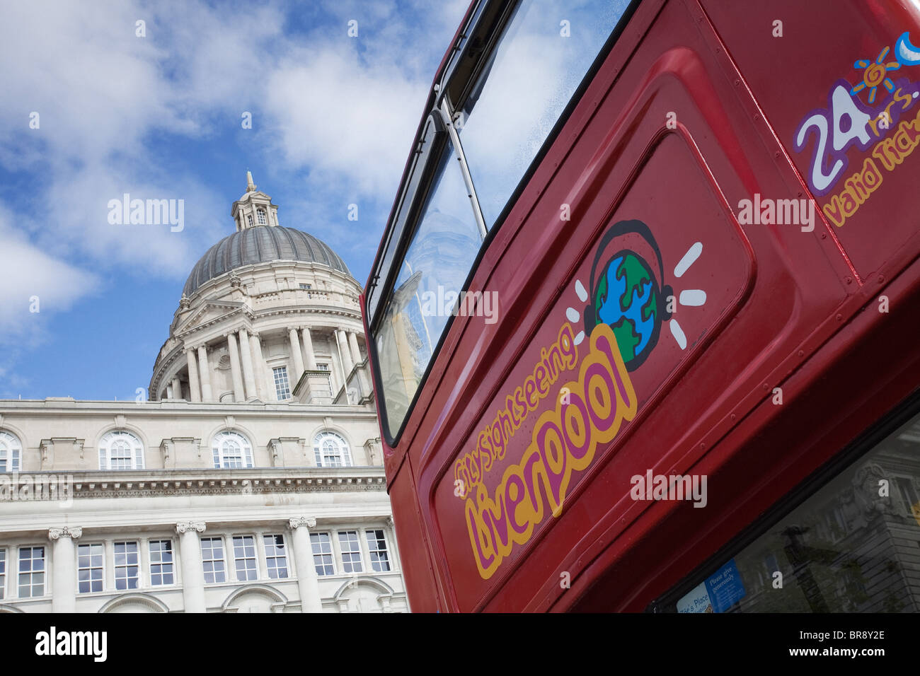An open topped, red, double decker bus in front of the Port of Liverpool Building in Liverpool Stock Photo