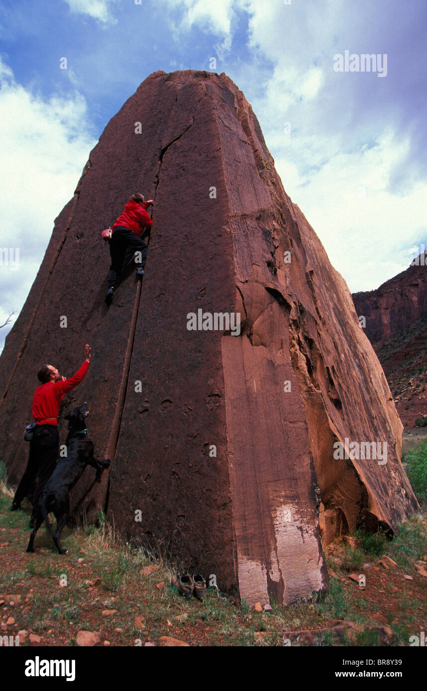 One man spotting another man bouldering up a crack Stock Photo - Alamy