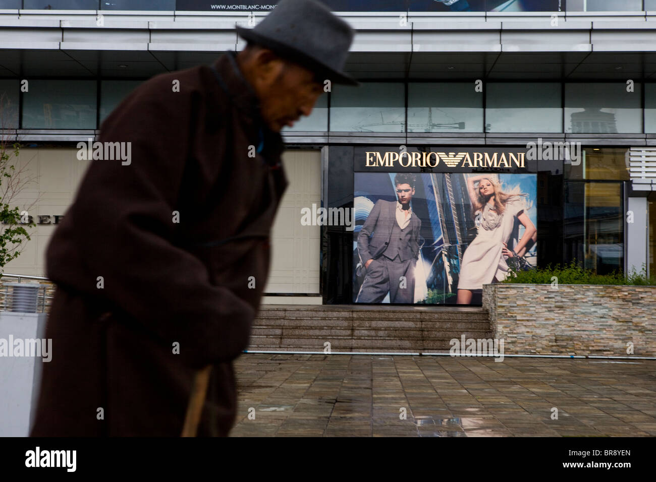 Old man walks passed signs of development and consumerism in Ulan Bataar, capital of Mongolia, Asia Stock Photo