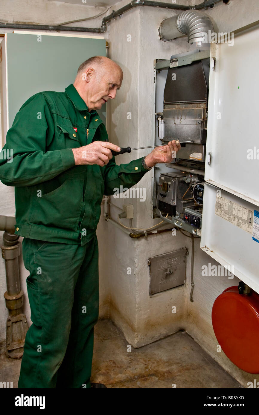 Heating and sanitary technician testing and adjusting a gas heater