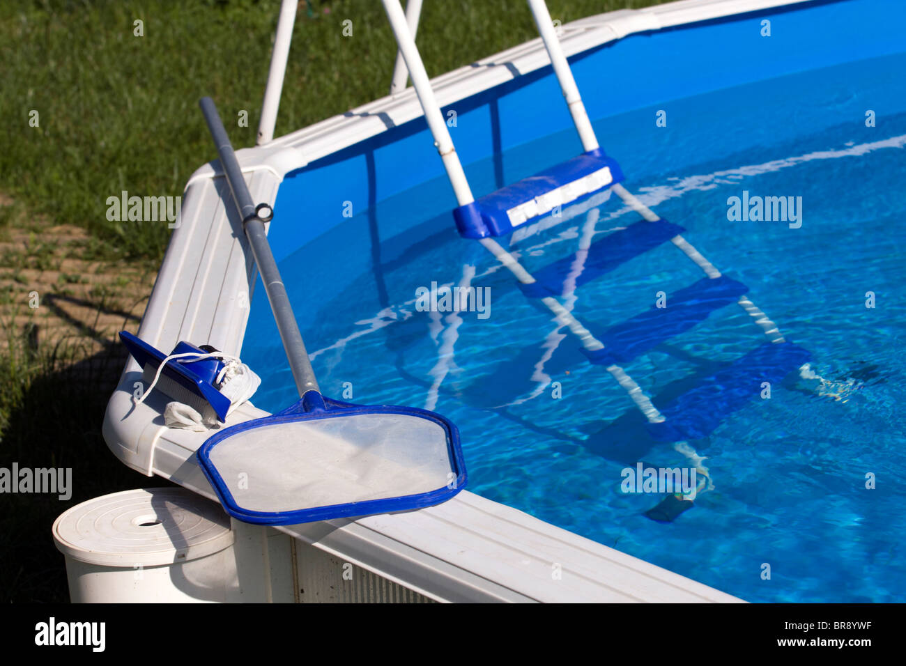 Garden pool with cleaning net, brush and ladder Stock Photo Alamy
