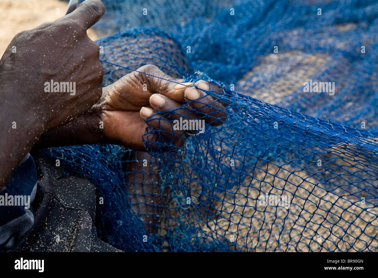 Close up of hands mending a net Stock Photo