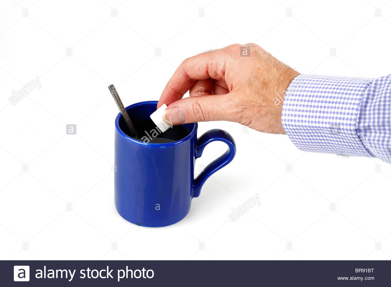Adding a sugarlump to a freshly made mug of coffee Stock Photo