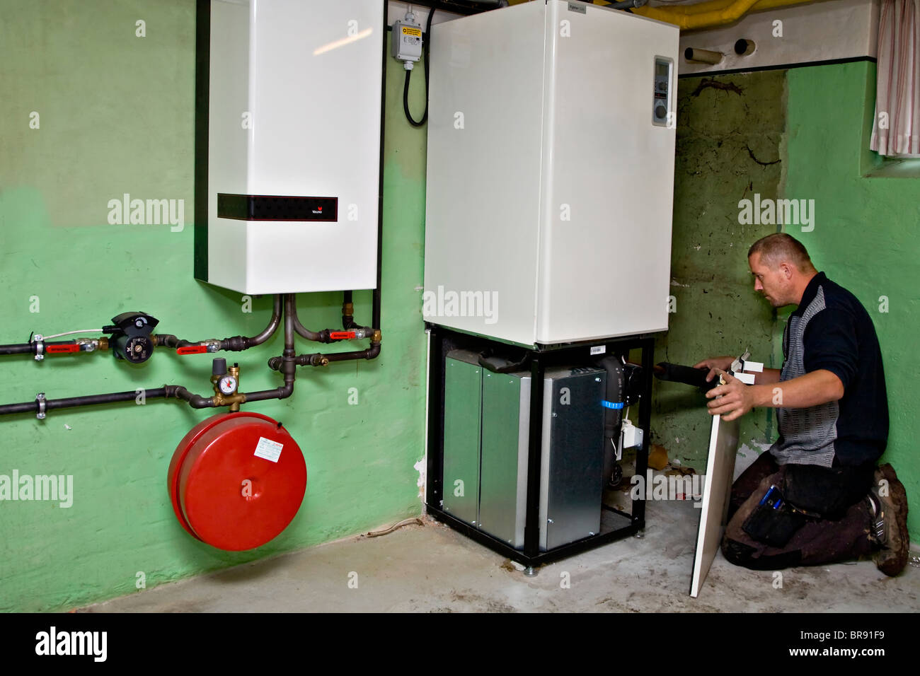 Heating and sanitary technician testing and adjusting a geothermal