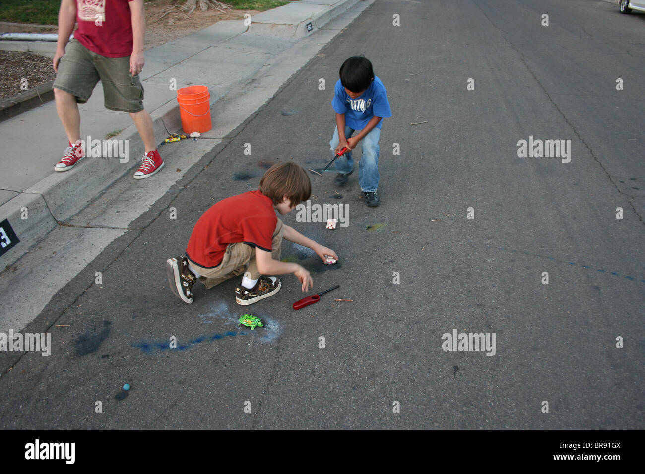 children lighting firecrackers in the street.  Southwestern United States, fourth of july holiday. Stock Photo