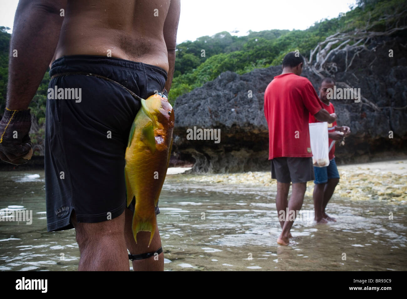 A fish hangs on a makeshift belt of a spear fisherman. Stock Photo