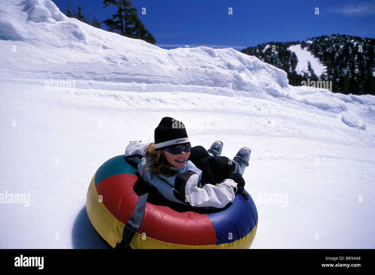 Kid sliding on snow in a tube Stock Photo Alamy
