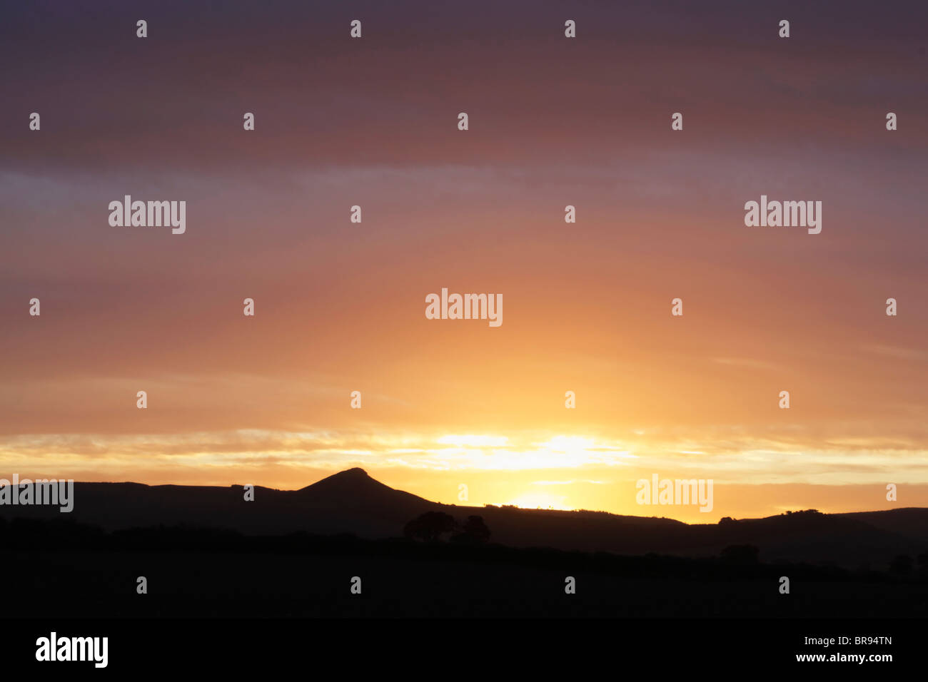 Dawn with the sun just about to rise over Roseberry Topping in the North York Moors national park Stock Photo