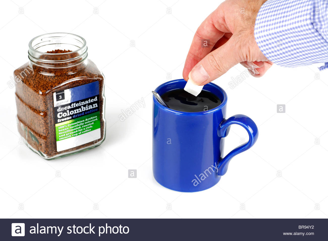 Adding a sugarlump to a freshly made mug of coffee Stock Photo