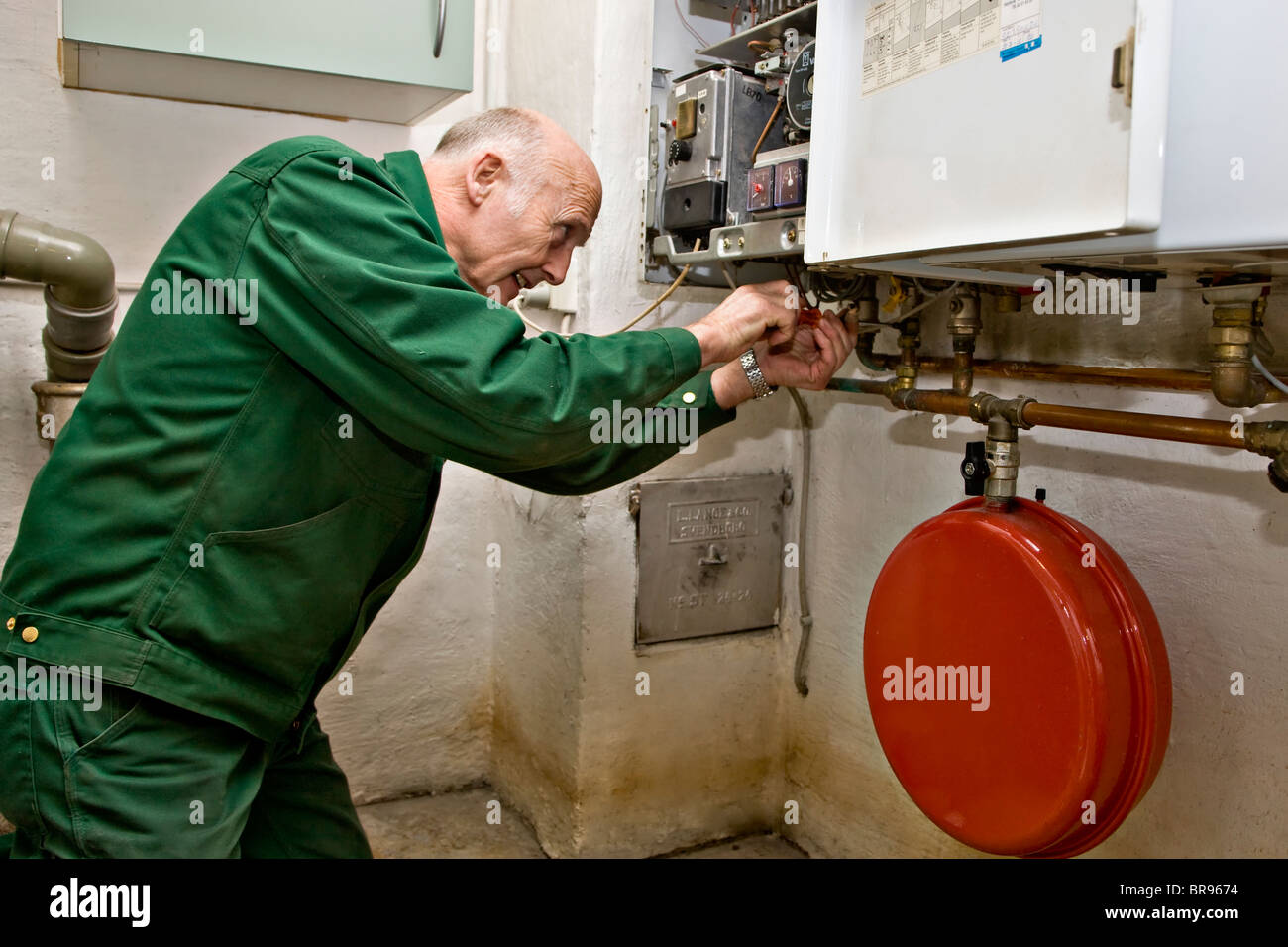 Heating and sanitary technician testing and adjusting a gas heater