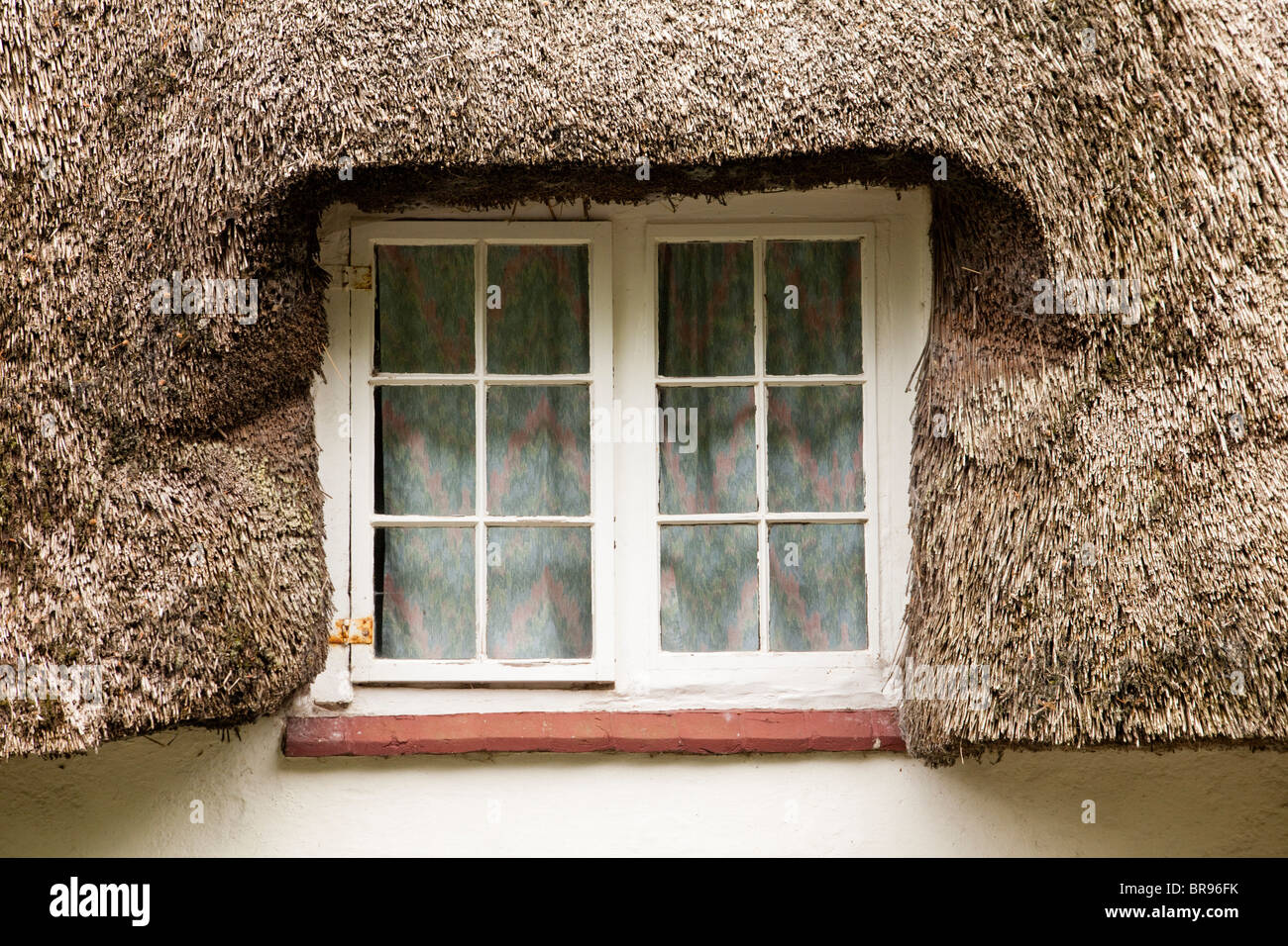 A traditional thatched roof and cottage window, Dorset, UK Stock Photo