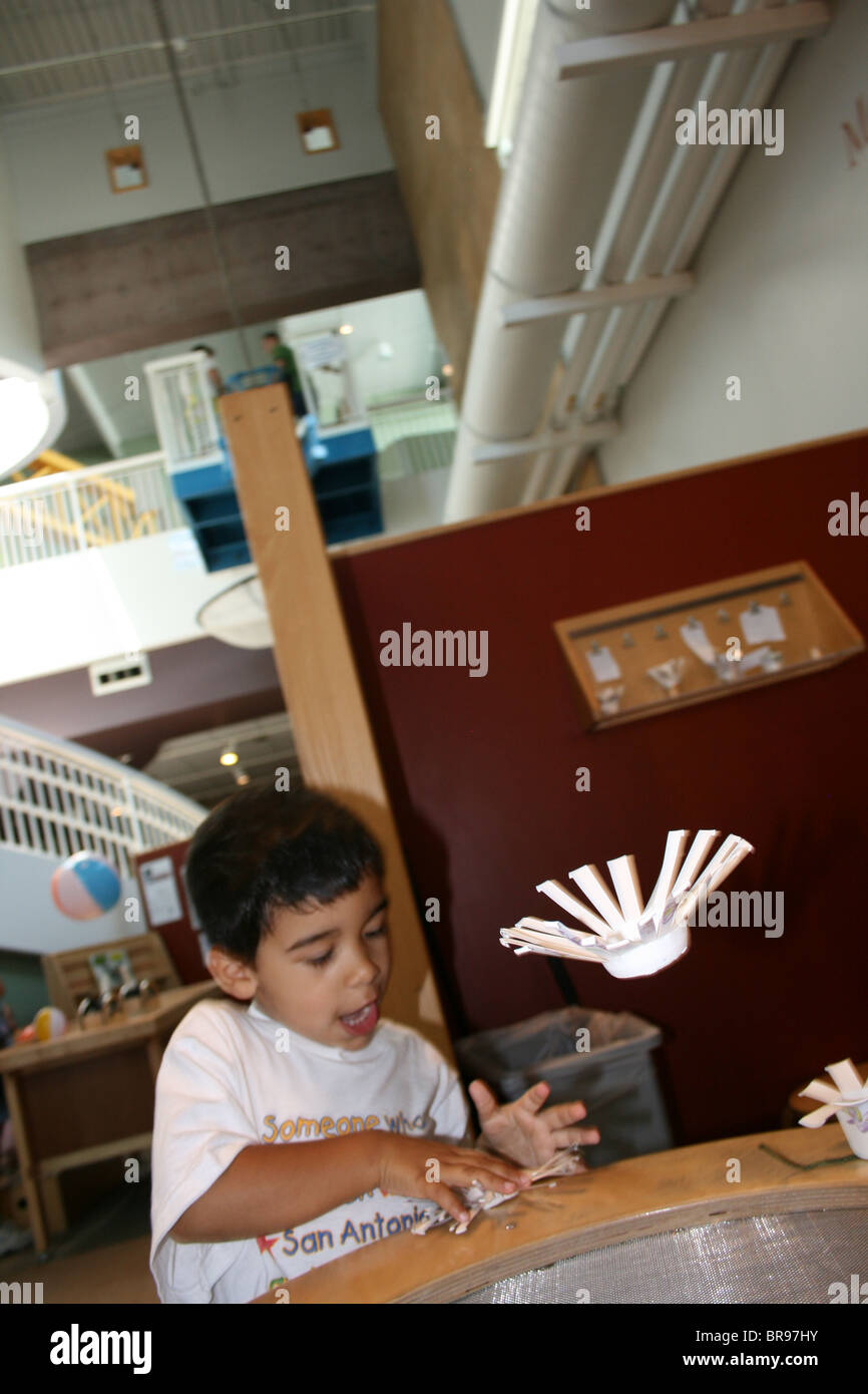 Little boy playing with a wind machine, making paper helicopters, experimenting with flight. Stock Photo