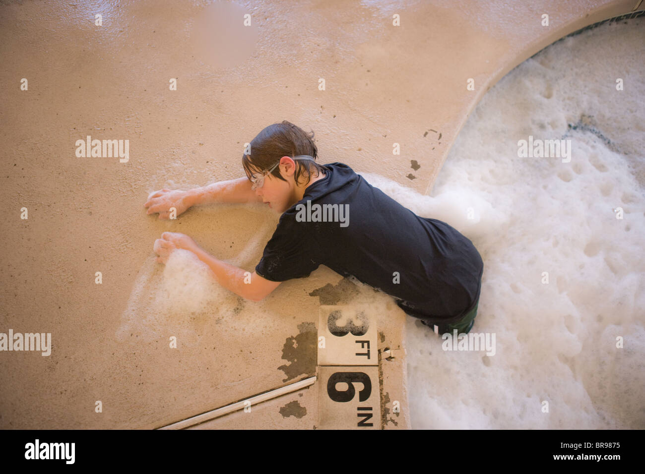 eight year old boy climbing out of a jacuzzi, hot tub, exhausted Stock Photo