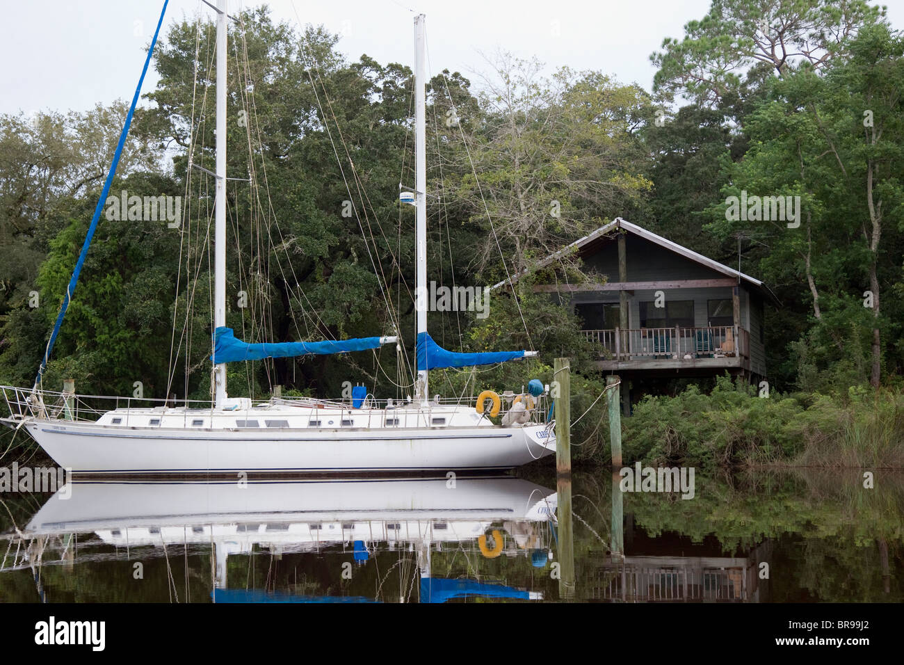 A large private sailboat tied up to dock outside a home on the Bayou in Bayou La Batre, Alabama Stock Photo