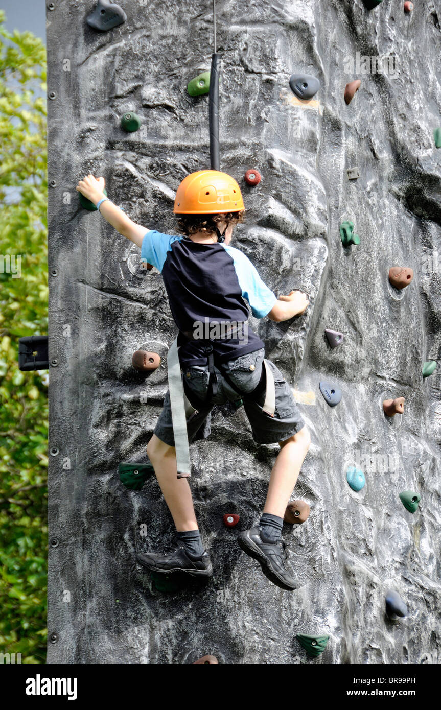 Young boy wareing helmet on freestanding climbing wall Stock Photo