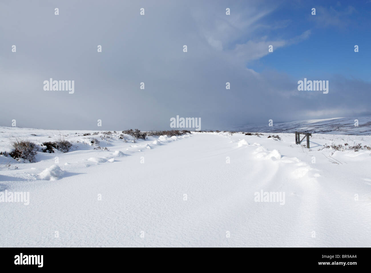 Snow covered road on Kildlae Moor in North York Moors national park with a snow storm approaching Stock Photo
