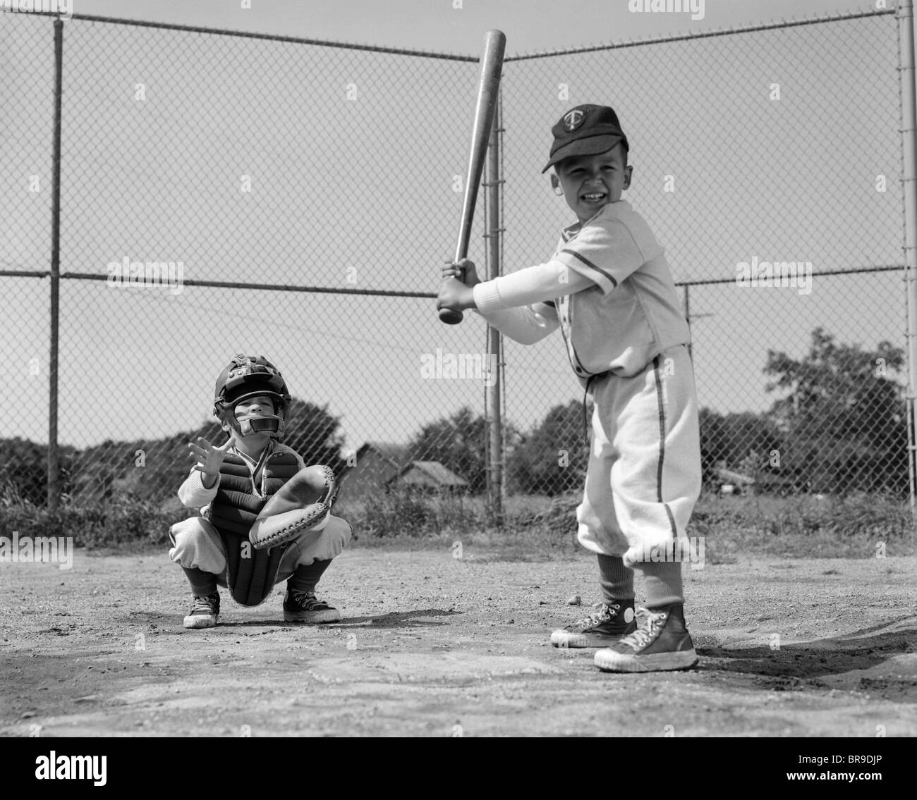 1960s TWO BOYS PLAYING BASEBALL BATTER AND CATCHER AT HOME PLATE Stock Photo