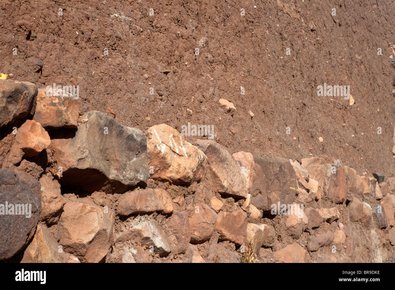 Stone and adobe, (mud brick), form a contrast of building materials for the walls of a house at Pucara, Peru. Stock Photo
