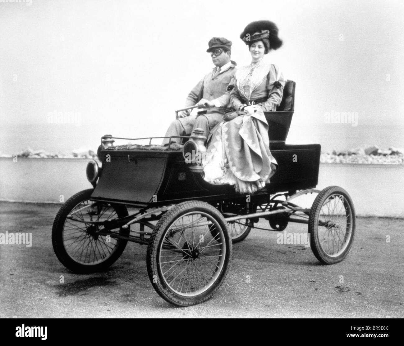 1890s 1900s COUPLE RIDING IN ANTIQUE AUTOMOBILE HORSELESS CARRIAGE Stock Photo