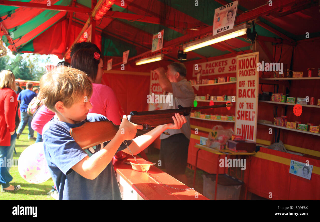 Boy shooting with an air rifle in an arcade game at Challock Goose Fair