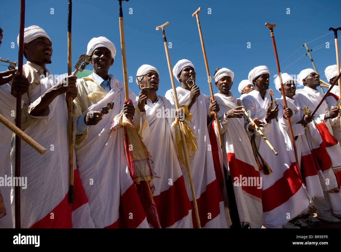 Group of priests dressed in ceremonial clothes chanting and dancing in procession during Timkat festival in Lalibela Ethiopia Stock Photo