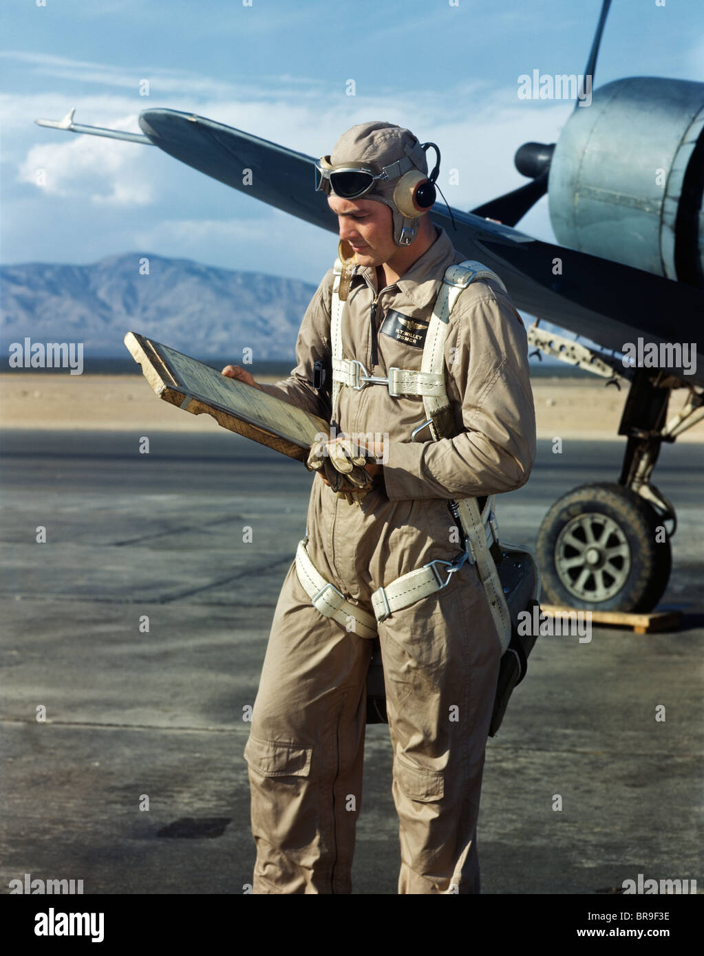 1940s AIR FORCE PILOT STANDING BY PLANE GOING OVER CHECKLIST FLIGHT PLAN  WEARING FLYING GOGGLES HELMET COVERALLS AND PARACHUTE Stock Photo - Alamy