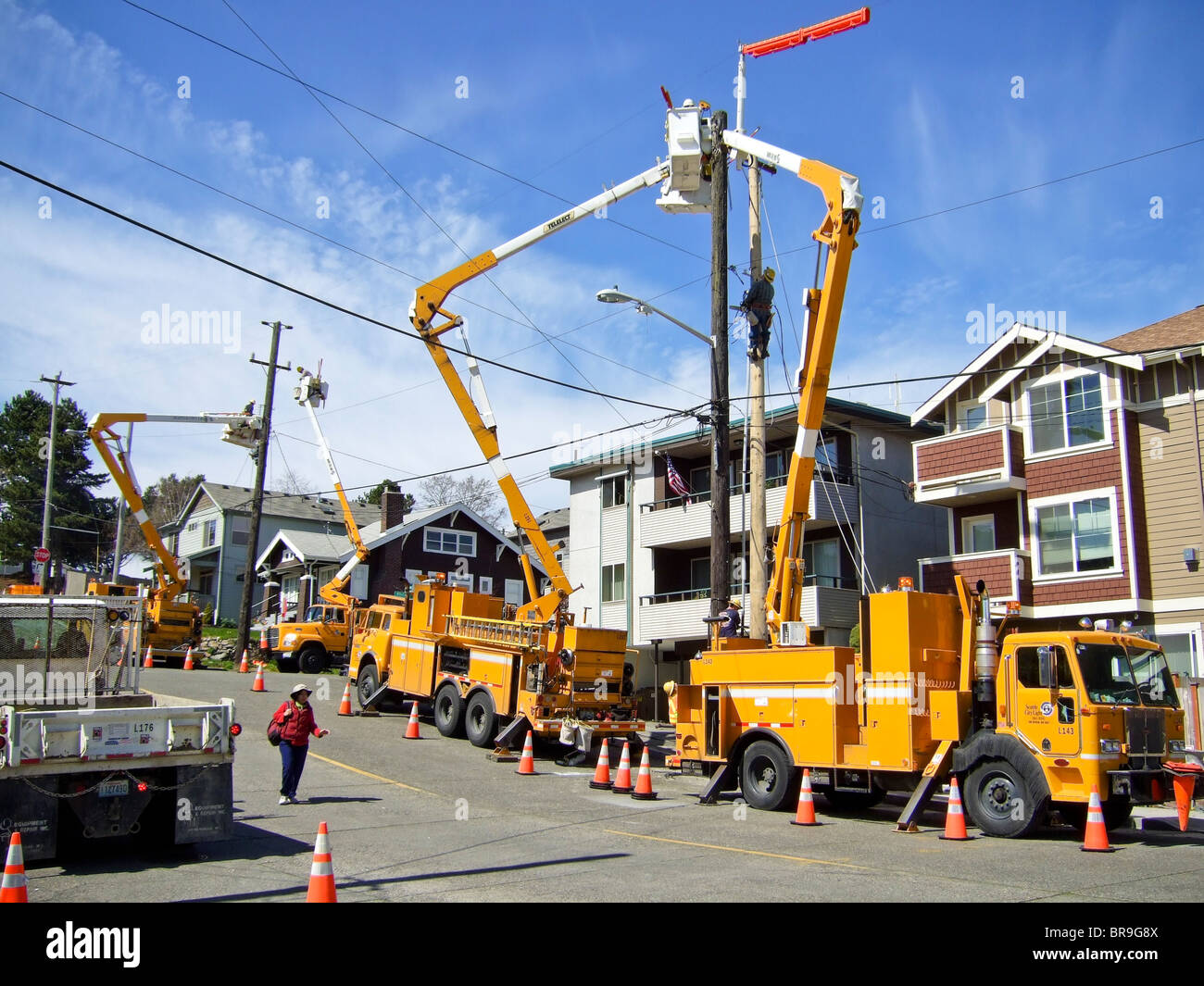 A Woman Walks Past Several Public Works Repair Trucks In The Stock Photo Alamy