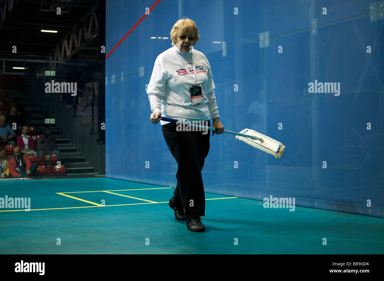 volunteer cleaning a squash court at the British Grand Prix event in