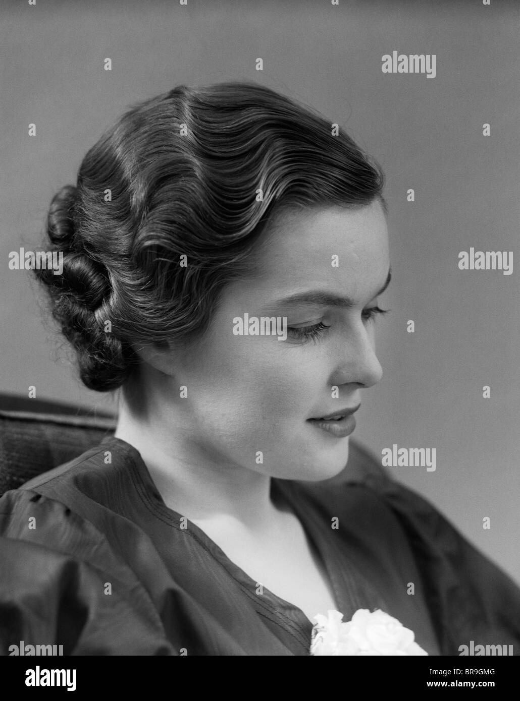 1930s THOUGHTFUL BRUNETTE WOMAN IN PROFILE WITH FINGER WAVY HAIR Stock Photo