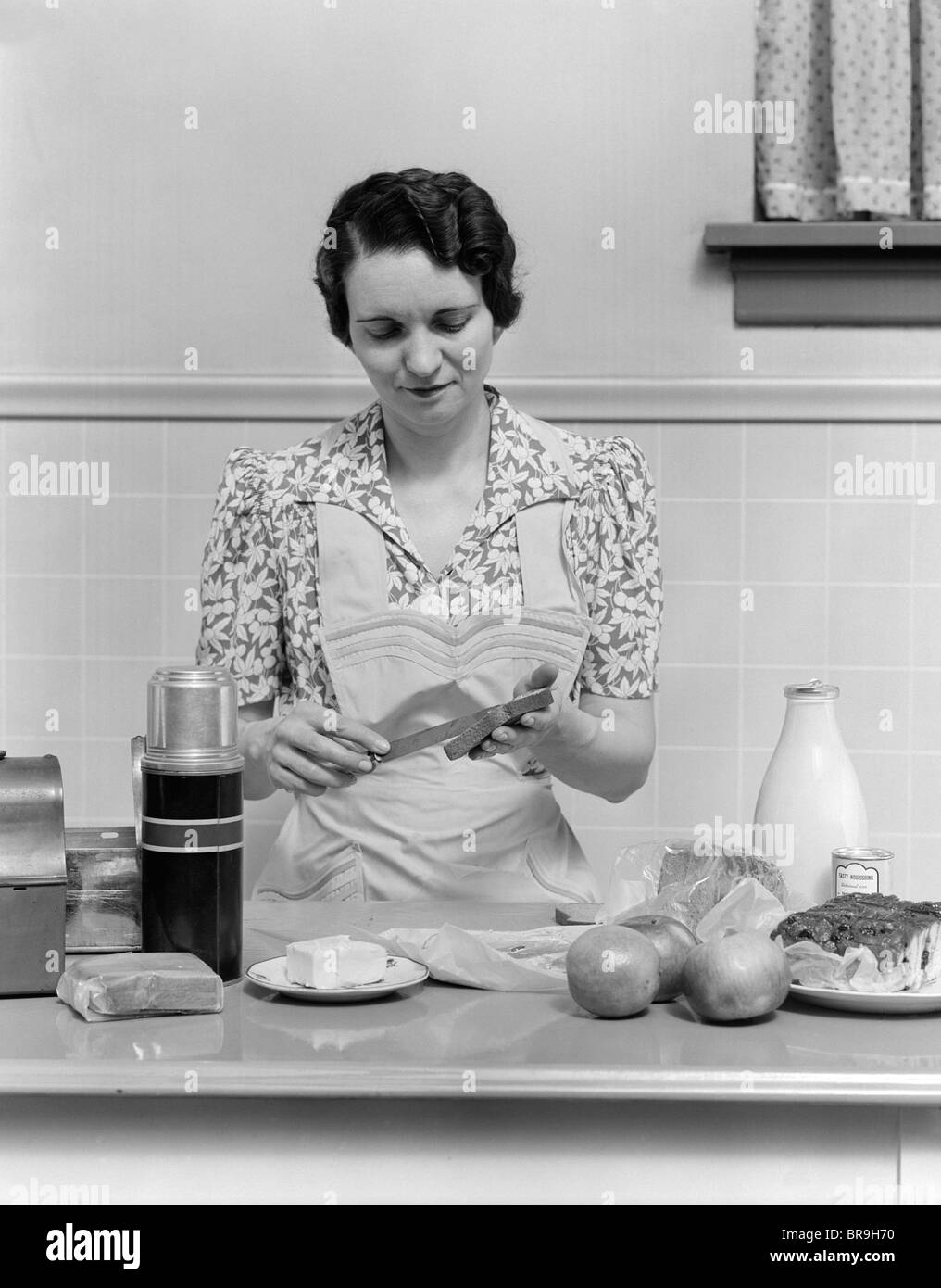 https://c8.alamy.com/comp/BR9H70/1930s-woman-housewife-in-kitchen-wearing-apron-making-sandwich-packing-BR9H70.jpg