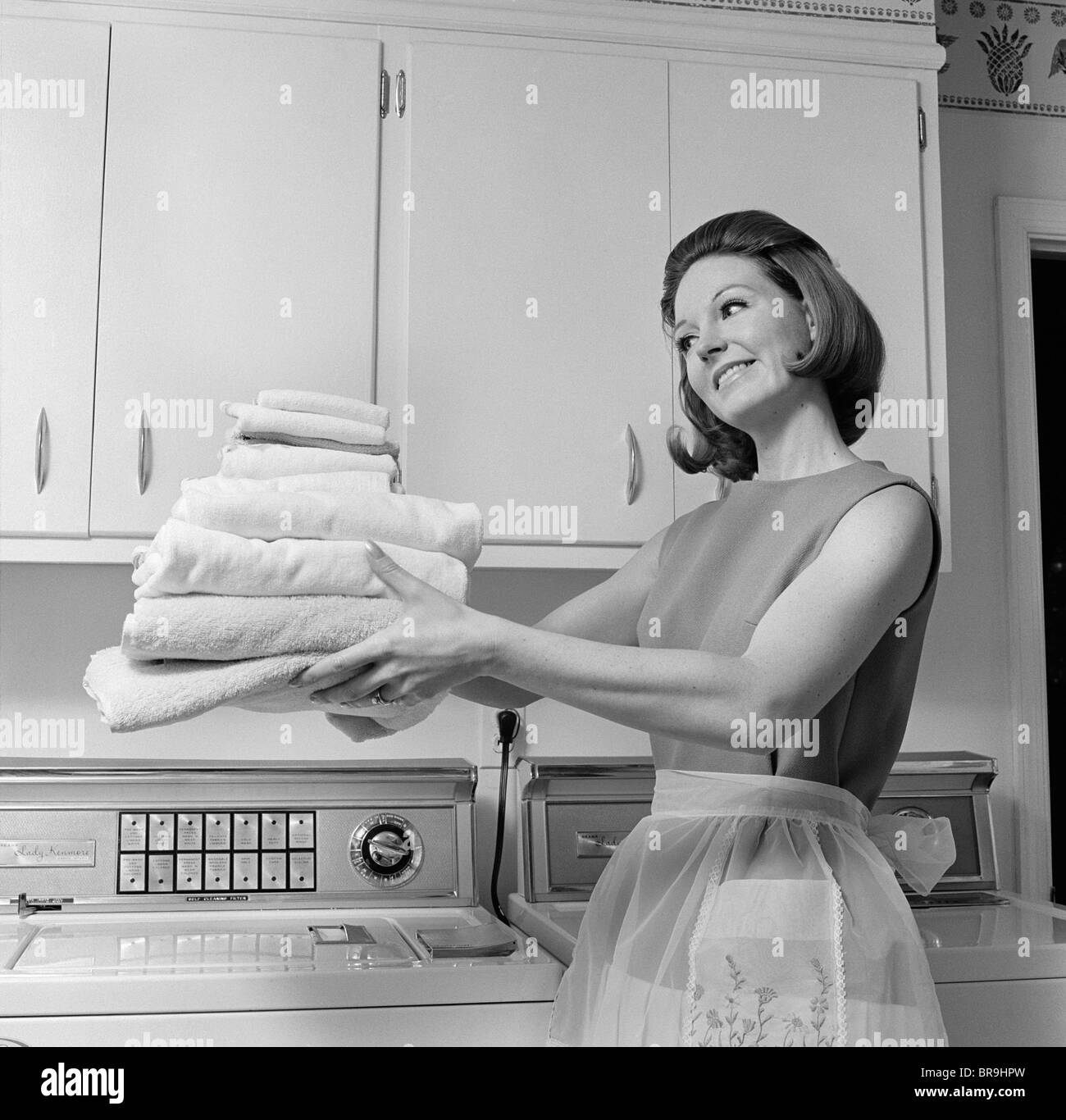 1960s SATISFIED WOMAN HOMEMAKER HOLDING FOLDED LAUNDRY Stock Photo