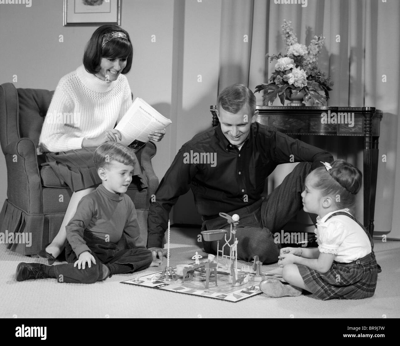 1960s FAMILY CHILDREN PLAYING GAME IN LIVING ROOM MOUSETRAP Stock Photo