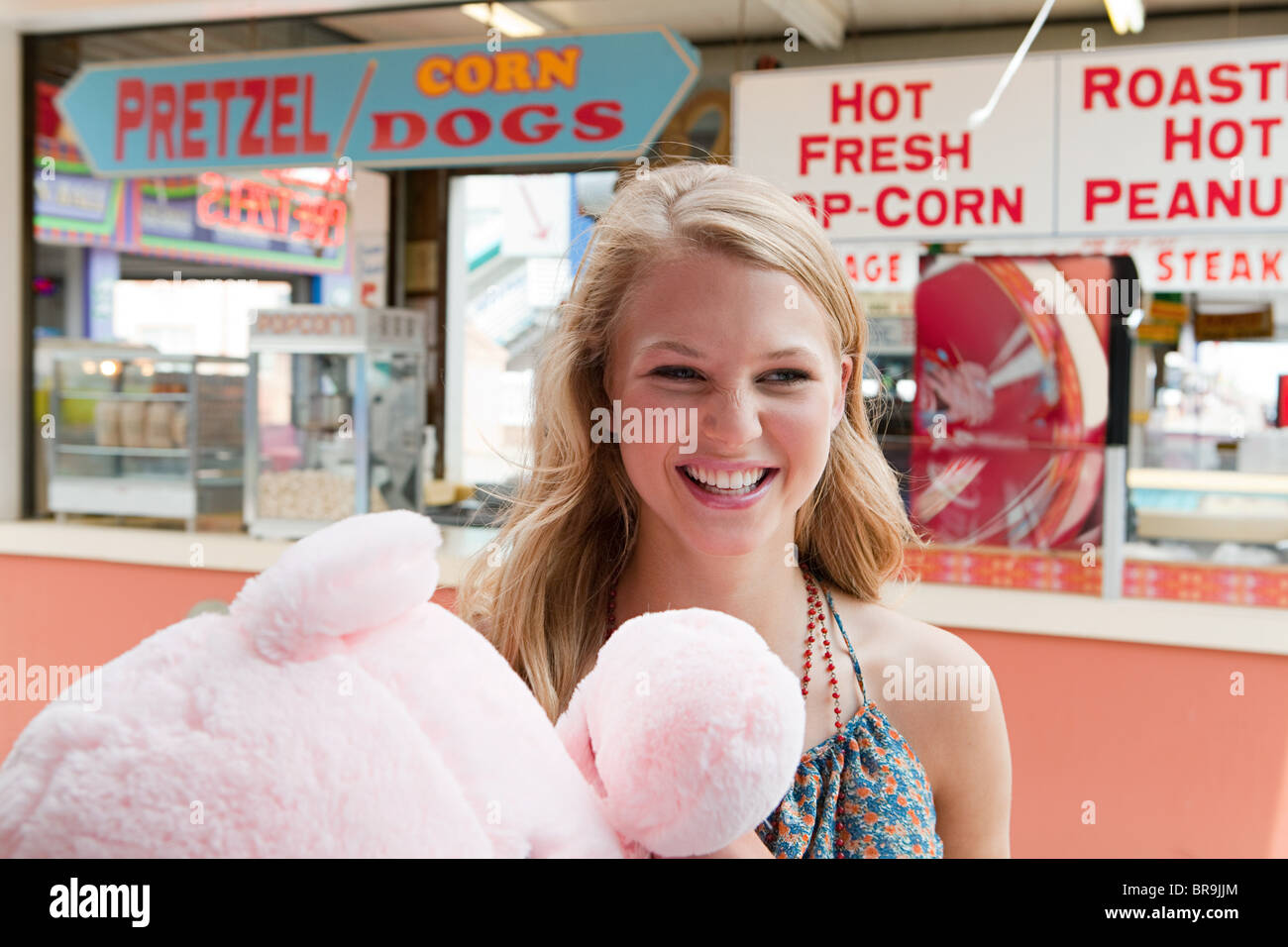 Teenage girl at fun fair with teddy bear Stock Photo