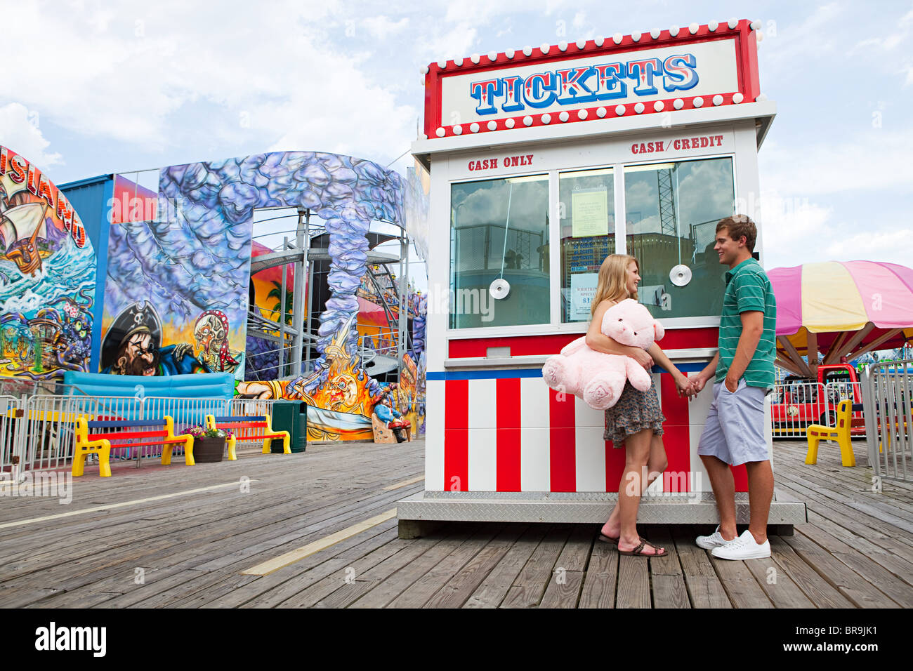 Teenage couple at fun fair ticket booth Stock Photo Alamy