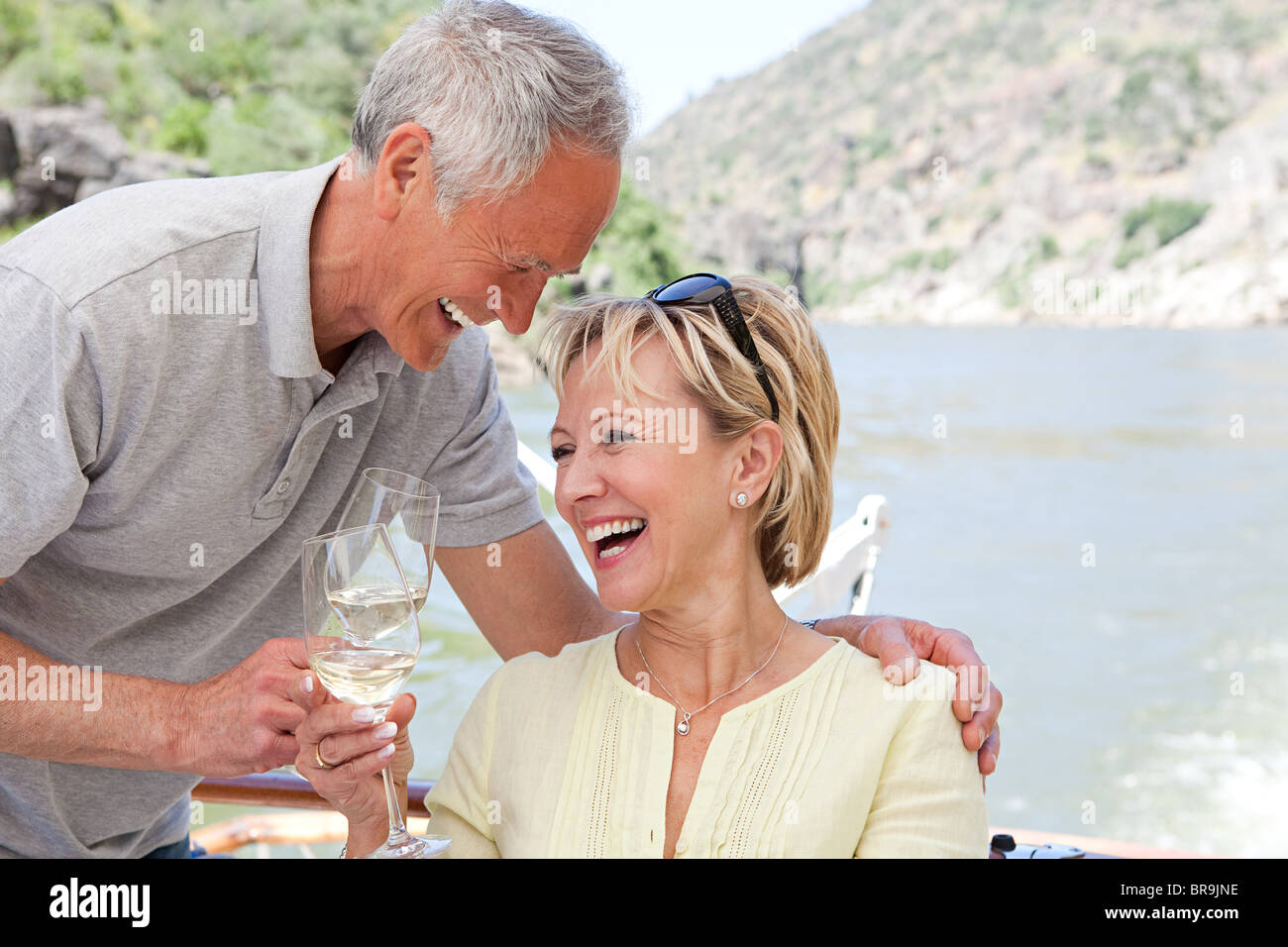 Senior couple with glasses of wine on a boat holiday Stock Photo