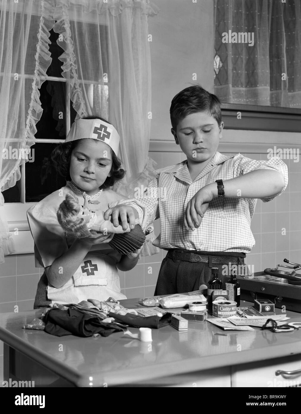 1950s TWO CHILDREN PLAYING DOCTOR NURSE Stock Photo