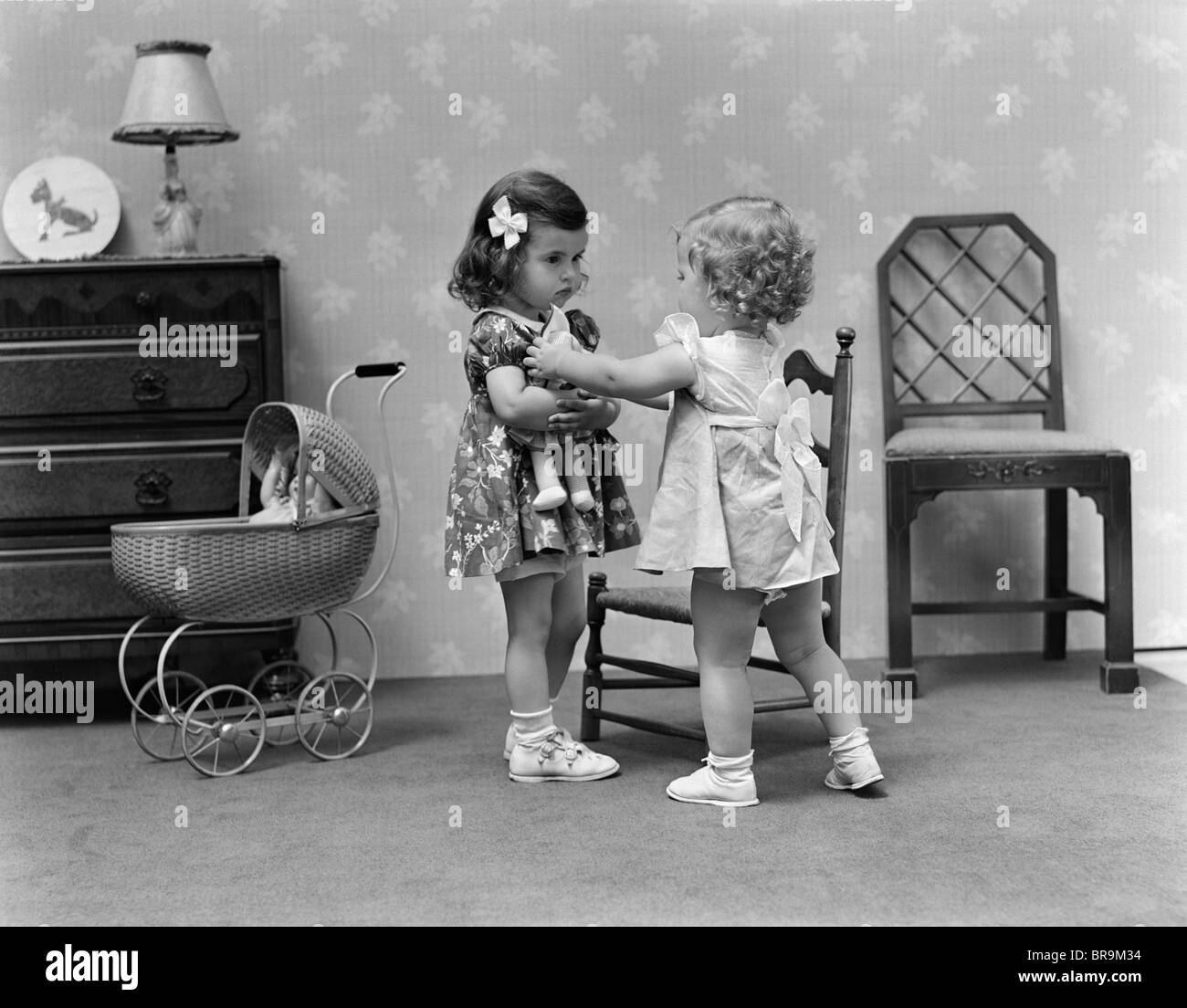 1940s TWO GIRLS PLAYING WITH DOLLS Stock Photo