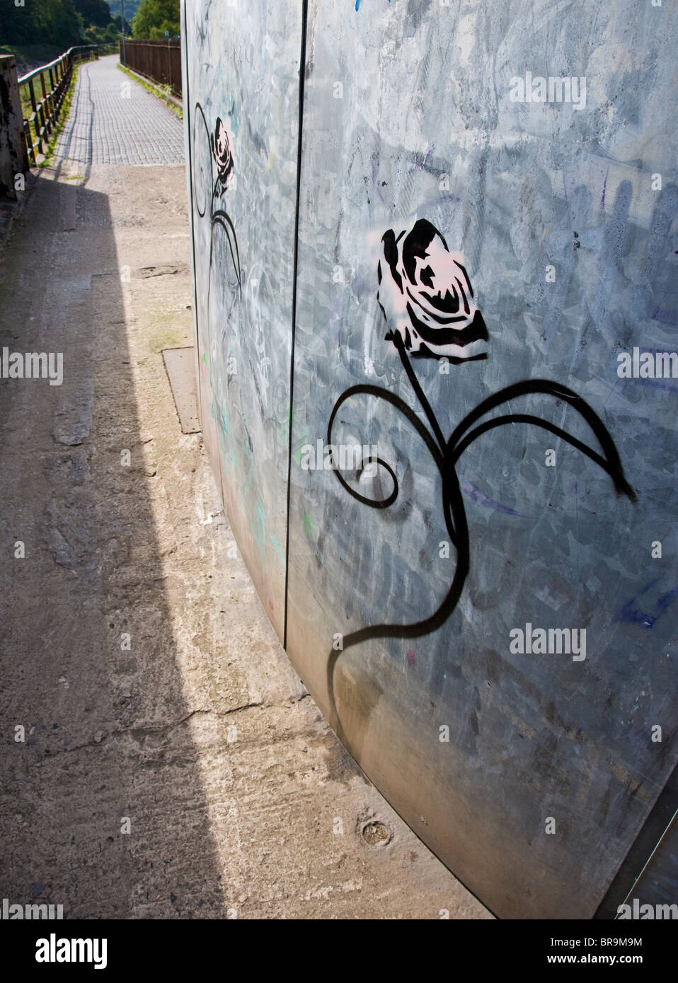 Banksy style sinuous anthropomorphic rose stencil graffiti on a metal building by the river Avon in Bristol Stock Photo